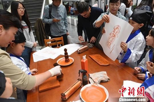 圖為現(xiàn)場展示雕版刷印技藝。　楊艷敏 攝