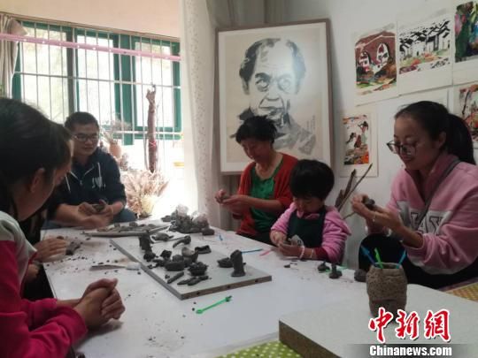 劉雪玲和孩子家長一起創(chuàng)作泥塑作品。　鐘欣 攝
