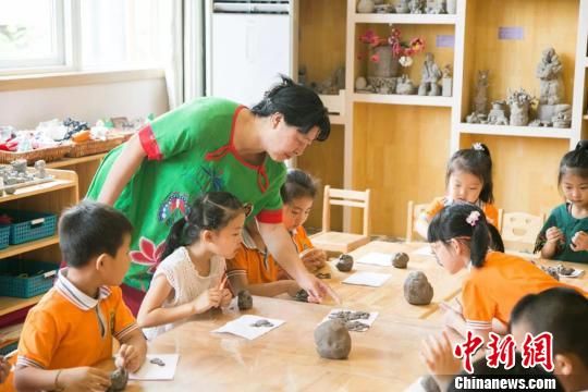 圖為劉雪玲正在給幼教中心的孩子上泥塑課。　鐘欣 攝