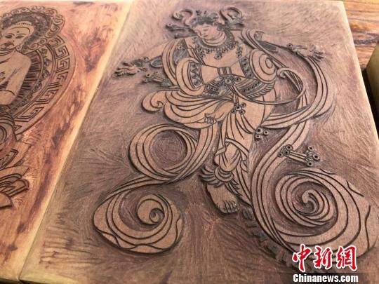 來源于敦煌壁畫中的菩薩、供養(yǎng)人、飛天等形象經(jīng)過藝術(shù)的渲染創(chuàng)作后，濃縮進(jìn)了一張張“袖珍版畫”中。　徐雪 攝