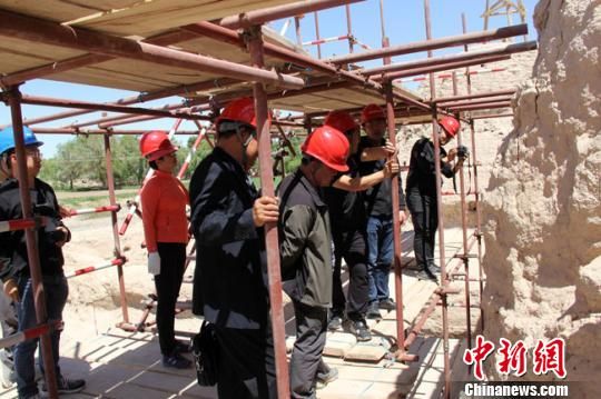 圖為設(shè)計、施工、監(jiān)理單位現(xiàn)場探討破城子遺址保護修復(fù)問題。　王建榮 攝