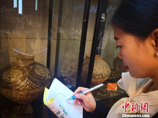 圖為施靜正在創(chuàng)作馬家窯彩陶元素的文創(chuàng)作品。　史靜靜 攝