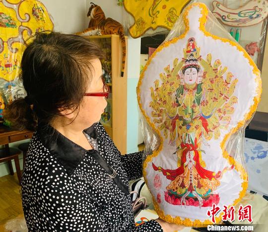 圖為丁永蓮向記者介紹“千手觀音”，該作品耗時半年。　高康迪 攝