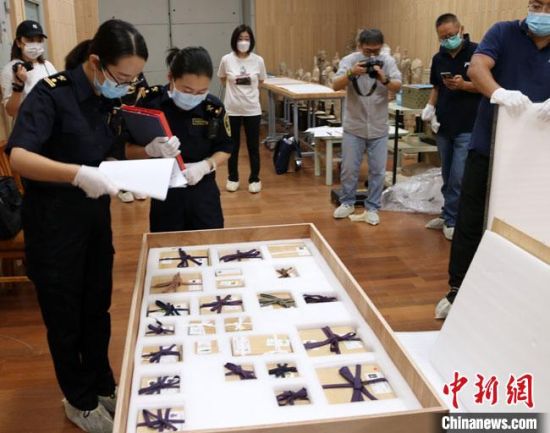 8月5日上午，蘭州海關所屬敦煌機場海關工作人員對300余件入境參展文物進行通關監(jiān)管查驗。　敦煌機場海關供圖