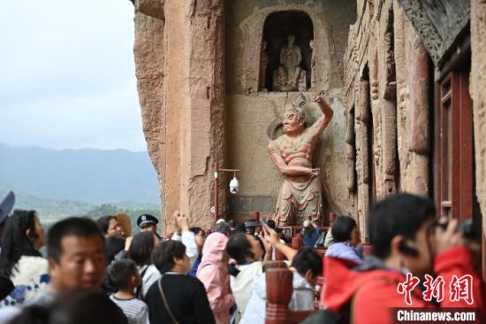 8月25日，參會人員與游客一同參觀麥積山石窟。李亞龍 攝