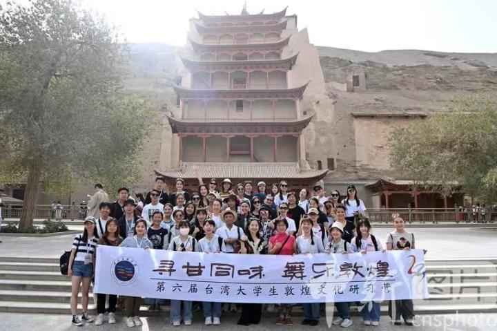 圖為營員在敦煌莫高窟景區(qū)合影。 中新社記者 九美旦增 攝