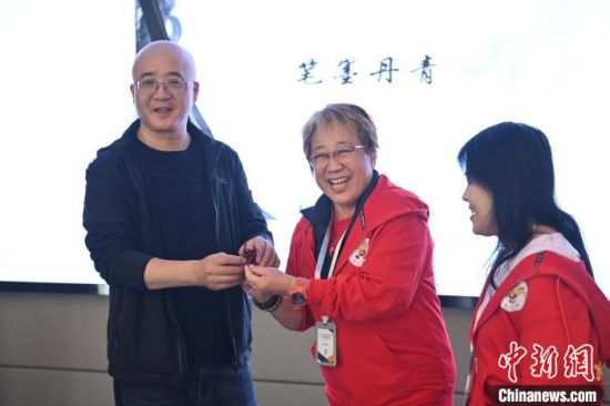 10月18日，林美玉(中)和甘肅書法老師(左)互贈象征吉祥好運的大象及書法作品。中新社記者 李亞龍 攝