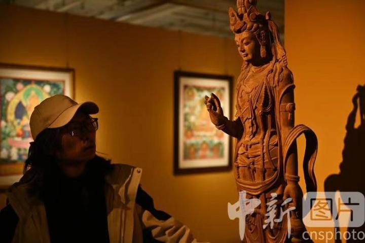 1月3日，在甘肅蘭州創(chuàng)意文化產(chǎn)業(yè)園內(nèi)，季茂杰觀察自己創(chuàng)作的敦煌木雕。