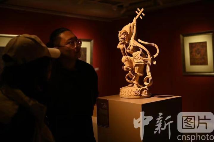 1月3日，在甘肅蘭州創(chuàng)意文化產(chǎn)業(yè)園內(nèi)，季茂杰向參觀者介紹自己創(chuàng)作敦煌木雕的過程。