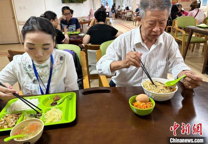 圖為王金城(右)和陳習(xí)珍(左)在蘭州一家社區(qū)養(yǎng)老中心用午餐。丁思 攝